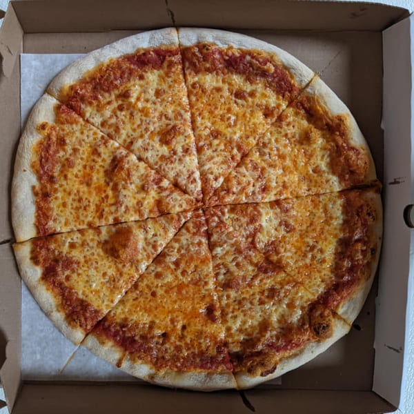 A whole cheese pizza, cut into eight slices, sits inside a cardboard delivery box.